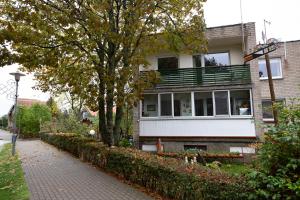 a brick building with a balcony on a street at Poilsis Preiloje in Preila +4 photos