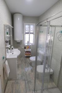uma casa de banho com um chuveiro, um lavatório e um WC. em Agradable Villa con piscina em Sevilha