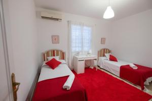 um quarto com 2 camas e um tapete vermelho em Agradable Villa con piscina em Sevilha