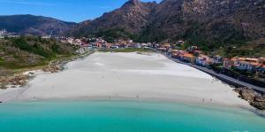 an aerial view of a beach with houses and mountains at Apartamento Centinela Do Mar in O Pindo
