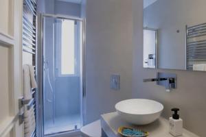 a white bathroom with a sink and a shower at A due passi dal mare in Trapani
