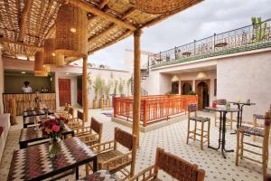 a restaurant with tables and chairs and a balcony at Riad Arabkech in Marrakech