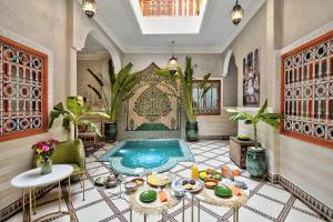 ein Wohnzimmer mit einem Pool in der Mitte des Zimmers in der Unterkunft Riad Arabkech in Marrakesch