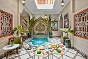 a living room with a pool in the middle of the room at Riad Arabkech in Marrakech