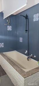 a bath tub in a bathroom with a blue wall at ToMa House in Pellaro