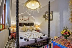 a bedroom with a four poster bed in a room at Riad Arabkech in Marrakech