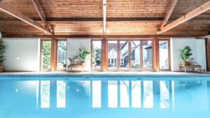 an indoor swimming pool with wooden ceilings and windows at Available For Contractors 2 Double Beds and Sofa Bed Private Parking in Harlow