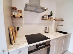 a white kitchen with a counter top and a sink at Self-contained annexe excellent location in Saltdean