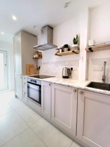a kitchen with white cabinets and a sink at Self-contained annexe excellent location in Saltdean