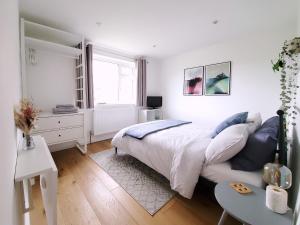 a white bedroom with a bed and a window at Self-contained annexe excellent location in Saltdean