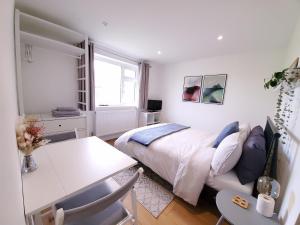 a bedroom with a bed and a table and a desk at Self-contained annexe excellent location in Saltdean