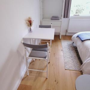 Saltdean的住宿－Self-contained annexe excellent location，一张白色的桌子和椅子,位于一个配有床的房间