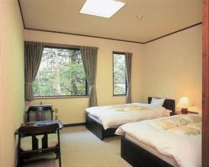 a hotel room with two beds and a window at Hirayunomori in Takayama