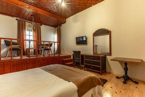 1 dormitorio con cama, escritorio y espejo en Sarı Konak, en Antalya
