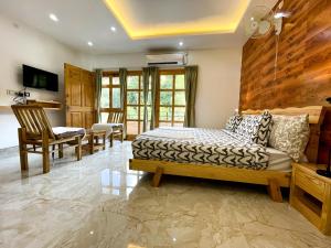 a bedroom with a bed and a table and chairs at The Wild Yak in Mandi