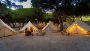 a group of tents with people sitting in front of them at Kampaoh Los Caños in Los Caños de Meca