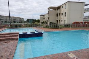 a large pool with blue water in front of a building at House 10-on-Sea in Hermanus