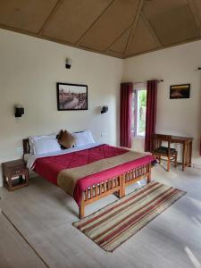 um quarto com uma cama grande e um cobertor vermelho em Majkhali Woods, Ranikhet, By Himalayan Eco Lodges em Rānīkhet