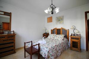 um quarto com uma cama, uma cómoda e um espelho em Casa Pepa em Igualeja