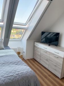 een slaapkamer met een bed en een tv op een dressoir bij Ferienwohnung Kamrath mit wunderschönem Ausblick in Neuruppin