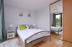 Un pat sau paturi într-o cameră la Victus Apartamenty, Apartament Pastelowy