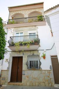 a building with a balcony and a door and windows at Casa Pepa in Igualeja