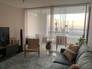 sala de estar con sofá, TV y mesa en Departamento frente al mar en Arica, en Arica