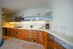 a kitchen with wooden cabinets and a counter top at Alterhome Swan villas with swimming pool and ocean views in Placencia Village