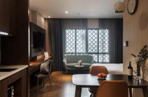 ein Wohnzimmer mit einem Bett und einem Esszimmer in der Unterkunft DHTS Business Hotel & Apartment in Ho-Chi-Minh-Stadt