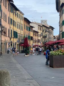 a city street with people walking around and buildings at LA PICCOLA MAGIA in Pisa