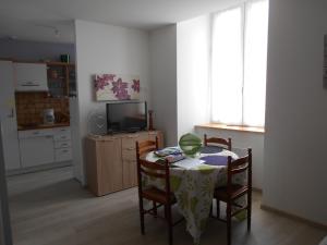 cocina con mesa y sillas y TV en BELLE appartement T2 neuf et en plein centre, en Ax-les-Thermes