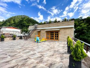 a patio with a playground and a building at The Wild Yak in Mandi