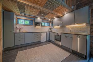 cocina grande con armarios blancos y techo de madera en Lapland Lodge, en Tepsa