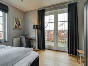 Schlafzimmer mit einem Bett und großen Fenstern in der Unterkunft Residentie Heesdael in Slenaken