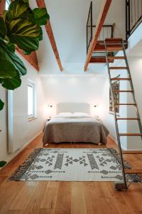 a bedroom with a bed with a ladder and a rug at Wunderschöne FeWo direkt am Meer mit Whirlpool & Sauna in Nordstrand