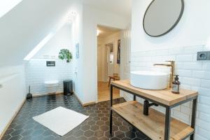 a bathroom with a sink and a mirror at Wunderschöne FeWo direkt am Meer mit Whirlpool & Sauna in Nordstrand