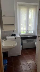 a white bathroom with a sink and a window at Cà Vittoria in Desenzano del Garda