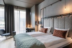 a bedroom with a large bed and a large window at Quality Hotel Hasle Linie in Oslo