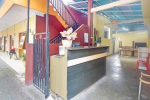 a bar in a restaurant with a staircase at OYO 90463 A2b Guesthouse in Manado