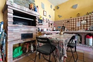 House Vochozka في لا أوروتافا: مطبخ مع طاولة وكرسيين ومدفأة