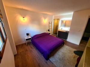 um quarto com uma cama roxa num quarto em Ferme de la Gibussière em Présilly