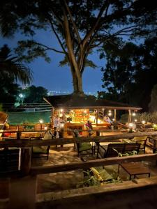 a restaurant with tables and a tree at night at Kampala Forest Resort - KFR Lodge in Kampala