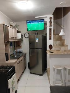 una cucina con frigorifero e una TV sul soffitto di Apartamento Cond. Privê em Caiobá 2 quadras da beira mar próximo ao Restaurante Casa do Camarão a Matinhos