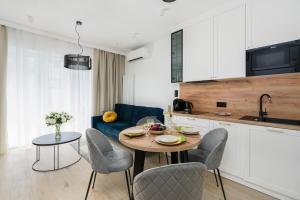 kuchnia i salon ze stołem i krzesłami w obiekcie Niedziałkowskiego 25 Apartments Stary Browar City Center by Renters Prestige w Poznaniu