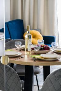 a table with a bottle of wine and a plate of food at Niedziałkowskiego 25 Apartments Stary Browar City Center by Renters Prestige in Poznań