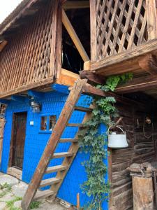 Cette maison bleue est accessible par un escalier en bois. dans l'établissement Casa de vacanta traditionala romaneasca, à Schiuleşti