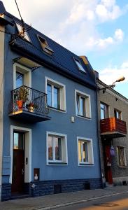 a blue house with a balcony on a street at Sweet Chocolate in Żywiec