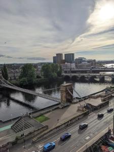 eine Brücke über einen Fluss mit Autos auf einer Autobahn in der Unterkunft Glasgow City Centre Waterfront Apartment in Glasgow