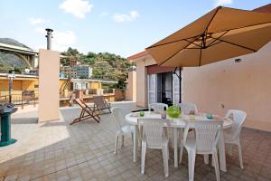a patio with a table and chairs and an umbrella at Attico di Silvy e Kikka in Arenzano