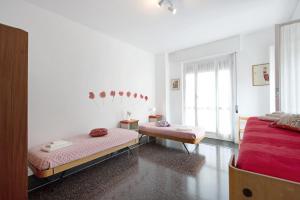 a white room with two beds and a window at Attico di Silvy e Kikka in Arenzano